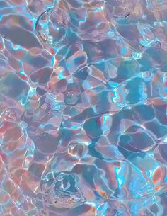 an image of water that is reflecting the sun on it's surface, with blue and pink hues