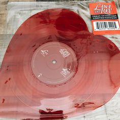 a red vinyl record sitting on top of a plastic bag