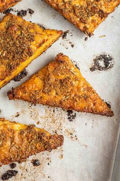 four pieces of pizza sitting on top of a baking pan covered in cheese and toppings