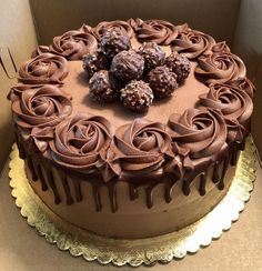 there is a chocolate cake with chocolate frosting on the top and roses on the bottom