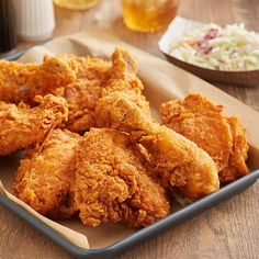 fried chicken on a plate with coleslaw in the background