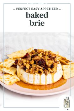 baked brie on a plate with crackers and fruit in the background text reads perfect easy appetizer - baked brie