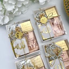 four cards with gold foil and pearls are on display next to some white hydranges