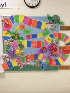 a board game with candy and candies on it in front of a wall clock