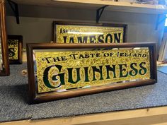 three framed signs are sitting on the counter in front of some other items that have been placed around them