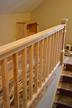 an unfinished staircase with wooden handrails in a home