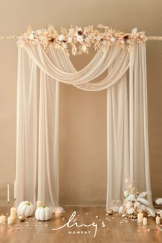 the wedding arch is decorated with flowers, candles and white pumpkins for an elegant touch