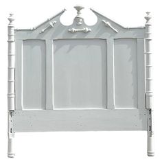 a white headboard with four posts and an arched top