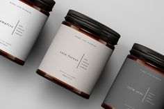 three jars with labels on them sitting next to each other in front of a white background