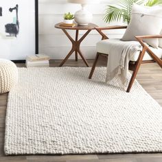 a living room with a white rug and chair