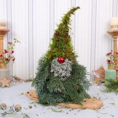 a fake christmas tree with decorations on it and other items around the room behind it