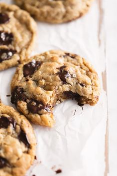 chocolate chip cookies on parchment paper with one broken in half