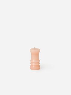 a small pink candle sitting on top of a white table