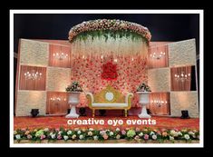 a stage decorated with flowers and candles for a wedding or special event, in front of a backdrop that says creative eye events