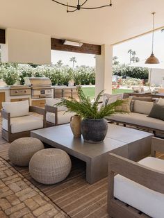 an outdoor living area with couches, tables and chairs