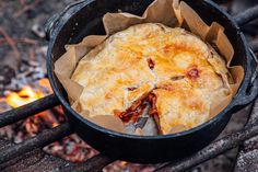 a pot filled with food sitting on top of a fire