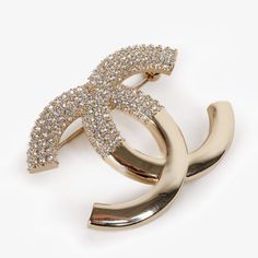 From Chanel’s I23 V Collection, This Stunning Cc Brooch In Champagne Gold-Tone Hardware Features An Upper Half Covered In Dainty Clear Crystals With Textured Edges And A Smooth Shiny Lower Half That Beautifully Contrasts With The Upper Half. Condition: New In Box With Booklet And Jewelry Pouch Approximate Measurements: Height X Width: 1.25” X 2” (3.5 Cm X 5 Cm) Composition: Metal, Strass Chanel Brooch, Eye Makeup Designs, Chanel Jewelry, Crystal Brooch, Champagne Gold, Makeup Designs, Jewelry Pouch, Gold Hardware, Clear Crystal