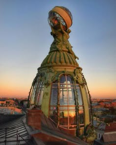 the top of a building with a statue on it's face and an open window