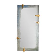 a mirror with gold spikes on it and a white wall in the backround