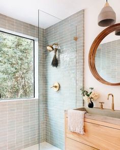 a bathroom with a sink, mirror and shower