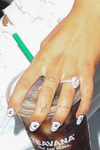 a woman's hand holding onto a starbucks cup with her nails painted on it