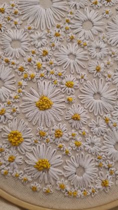 an embroidery project with yellow and white flowers