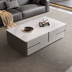 a modern living room with grey couches and white marble coffee table in the middle