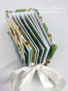 a close up of a folded book on a white surface with a ribbon tied around it