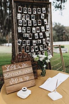 a table topped with pictures next to a wooden easel filled with flowers and photos