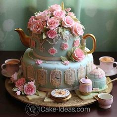 a cake decorated with pink flowers and teapots