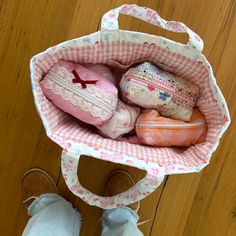 a person standing next to a bag filled with different types of items on top of a wooden floor