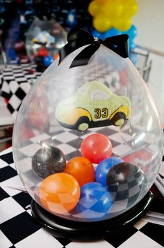 a glass bowl filled with colorful balls on top of a checkered table