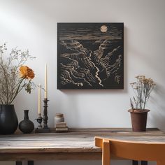 a wooden table topped with vases filled with flowers next to a painting on the wall