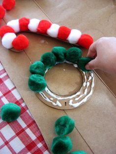 a child is making a christmas wreath out of felt