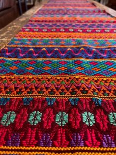 a colorful table runner is sitting on the floor