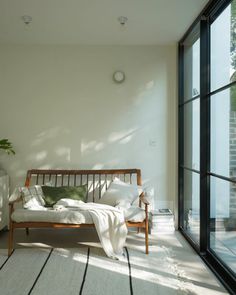 a bed sitting on top of a hard wood floor next to a large glass window