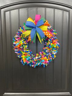 a colorful wreath on the front door of a house that is decorated with polka dots and ribbons