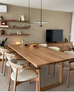 a dining room table with chairs and a television