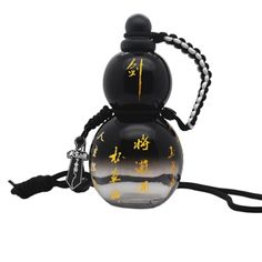 a black and yellow glass ball with writing on it's side, hanging from a cord