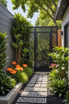 an outdoor garden with plants and flowers on the side of the house, along with a walkway