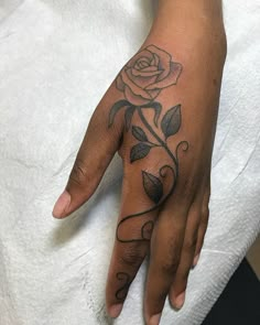 a woman's hand with a rose tattoo on it