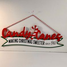 candy canes making christmas sweeter since 1932 hanging from the wall with red and green lettering