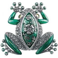 a green frog brooch with flowers and leaves on it's back