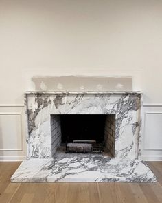 an empty fireplace in a room with white walls