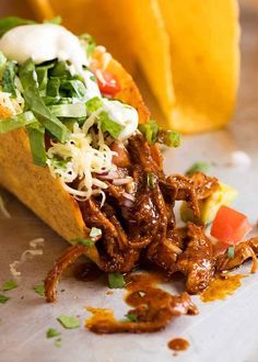 a taco filled with shredded meat and vegetables