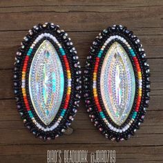 two colorful beaded oval earrings on a wooden surface with text overlay that reads, art's beadwork blog