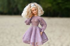 a doll with blonde hair wearing a purple dress