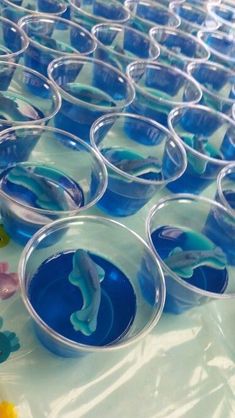 plastic cups filled with blue liquid on top of a table