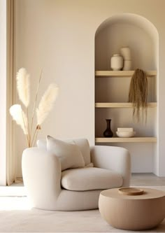 a living room with a white couch and shelves filled with vases on top of them