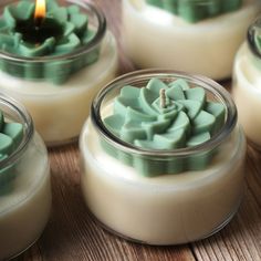 some candles are sitting in glass containers on a table